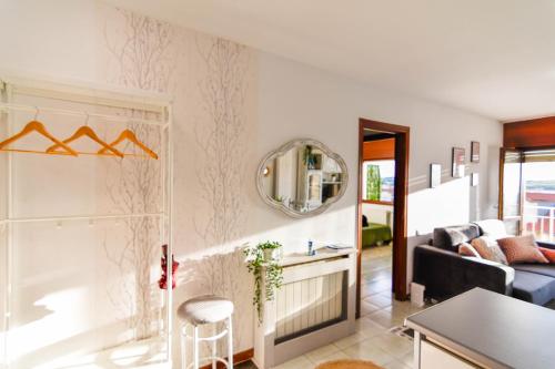 een woonkamer met een bank en een spiegel bij Apartamento con vistas al mar-Ola del atardecer in Mogro