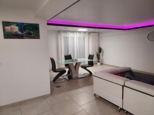 ein Wohnzimmer mit einem Tisch und einem Sofa in der Unterkunft Appartement bleu in Saintry-sur-Seine