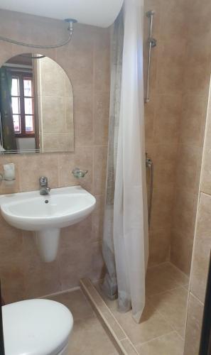 a bathroom with a sink and a toilet and a shower at Къща за гости Катлея in Tsarevo