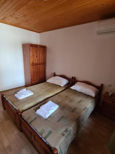 two twin beds in a room with wooden ceilings at Къща за гости Катлея in Tsarevo