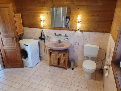 uma casa de banho com um lavatório, um WC e uma máquina de lavar roupa em Helle und idyllische 2 Zimmer Wohnung am Rande von Berlin em Berlim