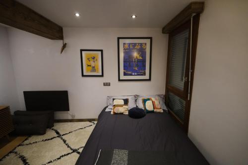 une chambre avec un lit et une télévision à écran plat dans l'établissement Au coeur du village, à Combloux