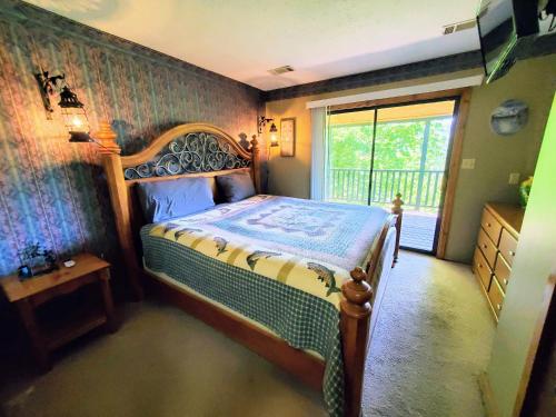 ein Schlafzimmer mit einem Bett in einem Zimmer mit einem Fenster in der Unterkunft Mountain Ridge in Pigeon Forge
