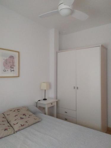 a bedroom with a bed and a white cabinet at Ático en el centro con terraza in Cádiz