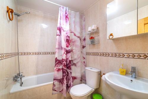 baño con cortina de ducha rosa y aseo en Precioso apartamento con Jacuzzi, en Torremolinos