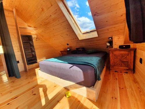 - une chambre avec un lit dans une pièce dotée d'une fenêtre dans l'établissement Domek Tuni, à Pewel Wielka