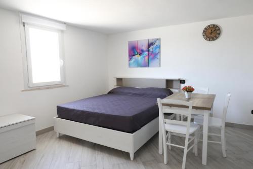 a white bedroom with a bed and a table at serendipity la terrazza house in Lecce