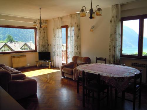 un soggiorno con tavolo e alcune sedie di Appartamenti Rosenberger a Molveno