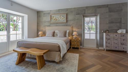 a bedroom with a large bed and two windows at Portuguese mansion close to marina, golf and beach. in Vilamoura