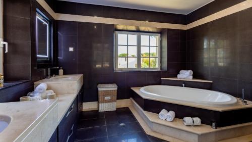 a large bathroom with a tub and a sink at Portuguese mansion close to marina, golf and beach. in Vilamoura