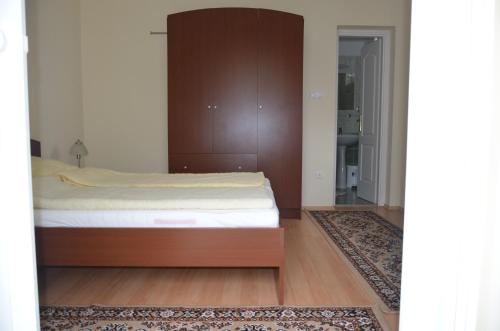 a bedroom with a bed with a wooden headboard at Villa Ladver in Hévíz