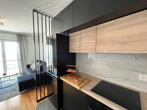 cocina con paredes negras y armarios de madera en Apartman J&M en Makarska
