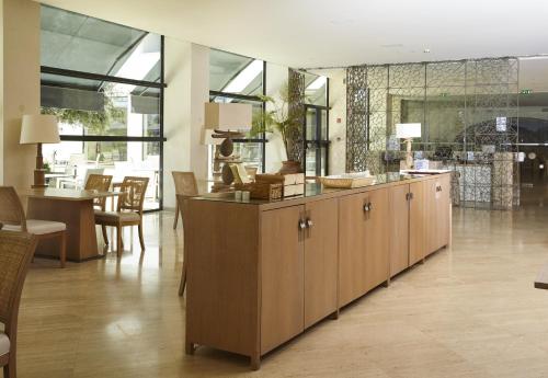 a kitchen with wooden cabinets and a dining room at Crowne Plaza Vilamoura - Algarve by IHG in Vilamoura