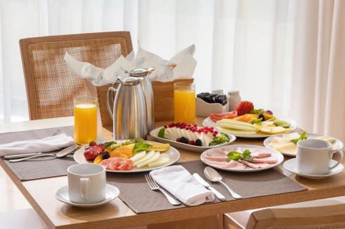 a table topped with plates of food and orange juice at Crowne Plaza Vilamoura - Algarve by IHG in Vilamoura