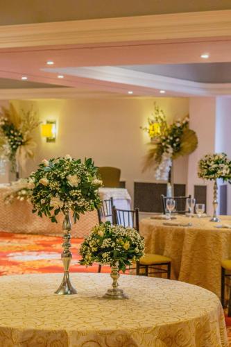 two vases with flowers on top of a table at Gamma Monterrey Gran Hotel Ancira in Monterrey