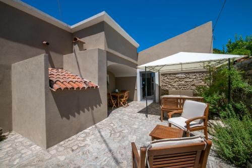 a patio of a house with chairs and an umbrella at Casa Franco in Paestum