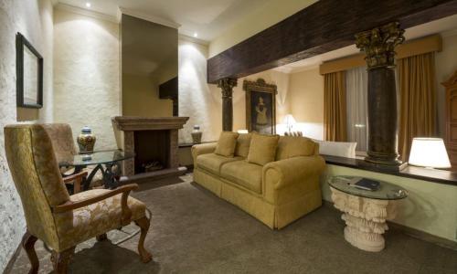 a living room with a couch and a fireplace at Quinta Real Aguascalientes in Aguascalientes