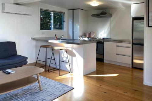 a kitchen with an island in the middle of a room at Tranquil Nest Escape with deck and garden in Auckland