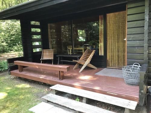 een veranda van een hut met 2 stoelen en een tafel bij Fins Boshuis in Meppen