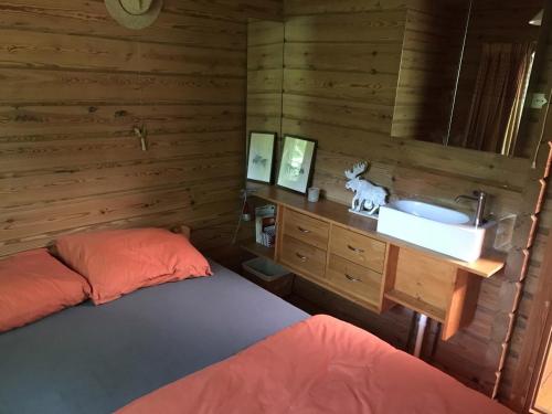 een slaapkamer met een bed en een wastafel bij Fins Boshuis in Meppen