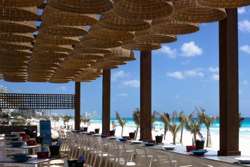 a restaurant with chairs and tables on the beach at Live Aqua Cancun - Adults Only - All-Inclusive in Cancún