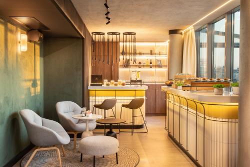 a restaurant with chairs and a counter with a table at Crowne Plaza Budapest by IHG in Budapest