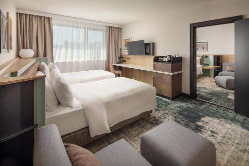 a hotel room with two beds and a television at Crowne Plaza Budapest by IHG in Budapest