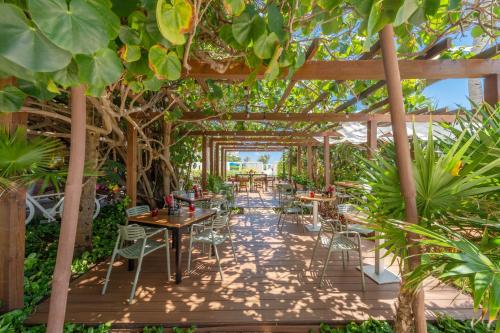 a restaurant with tables and chairs under a pergola at Live Aqua Cancun - Adults Only - All-Inclusive in Cancún