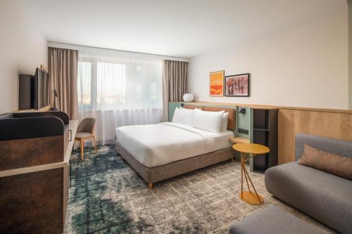 a hotel room with a bed and a couch at Crowne Plaza Budapest by IHG in Budapest