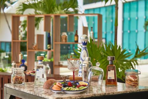a table with bottles and a plate of food on it at Live Aqua Cancun - Adults Only - All-Inclusive in Cancún