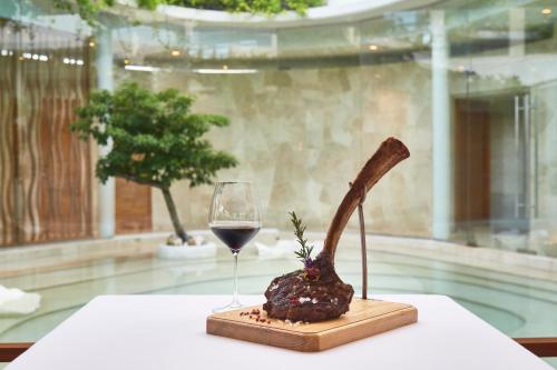 a glass of wine sitting next to a dessert and a knife at Live Aqua Cancun - Adults Only - All-Inclusive in Cancún