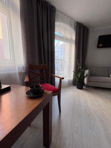 een woonkamer met een tafel en een rode stoel bij Kamienica 22 Old Town in Gdańsk
