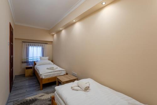 a small room with two beds and a window at Illés Hotel in Szeged