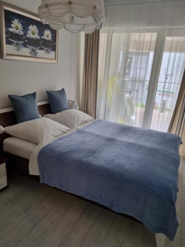 a bedroom with a large bed and a window at Playa Baltis Międzyzdroje Apartament Katharina in Międzyzdroje