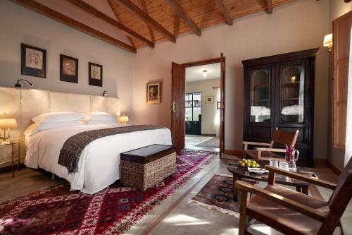 a bedroom with a large bed and a living room at LAS LIEBRES RESTAURANT & HOTEL in Colonia del Sacramento