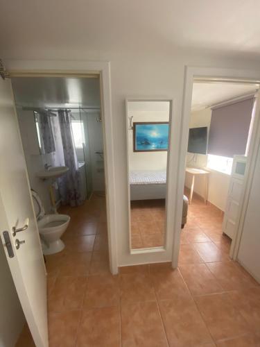 uma casa de banho com um quarto com uma cama e um WC em Cozy house in central Lysekil, 4-6 beds em Lysekil