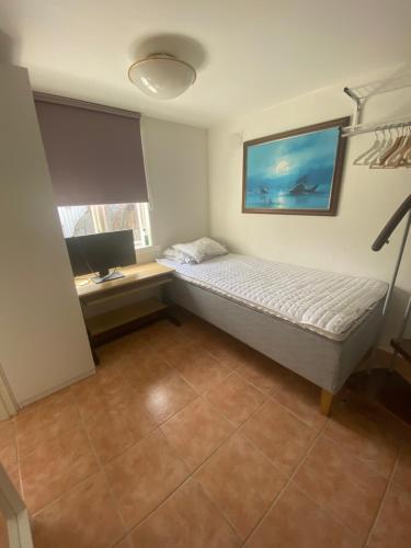 a bedroom with a bed and a desk with a computer at Cozy house in central Lysekil, 4-6 beds in Lysekil