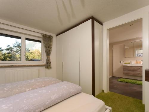 a bedroom with a bed and a large window at MyHome Apartments Ambach in Oetz