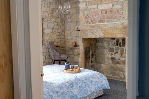 a stone room with a table and a stone fireplace at The Anchorage - sea views and beach on doorstep in Amble