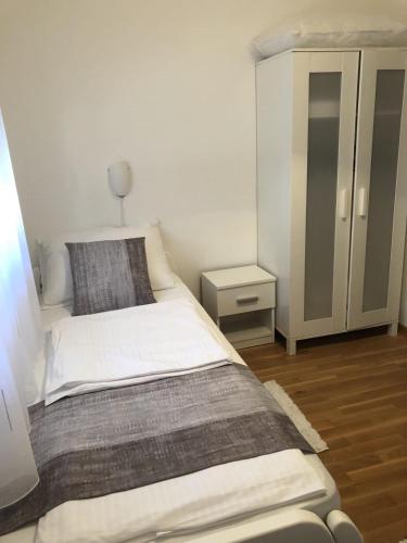 a small bedroom with a bed and a cabinet at Apartmani Gavran in Pirovac