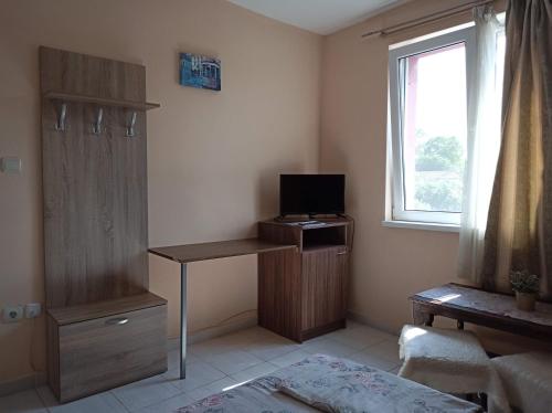 a room with a desk with a television and a window at Guest House 51 in Kranevo