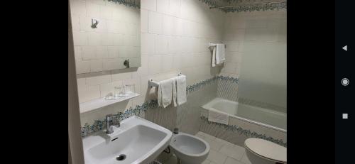 a bathroom with a sink and a toilet and a tub at La casa de la abuela in Narón