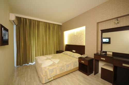 a hotel room with a bed and a mirror at Palmea Hotel in Marmaris