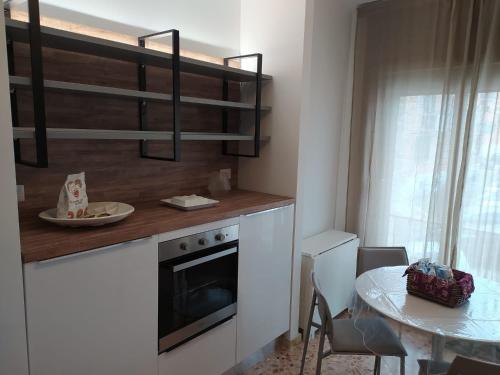 een keuken met een tafel en een aanrecht met een magnetron bij Apartments for you in Matera