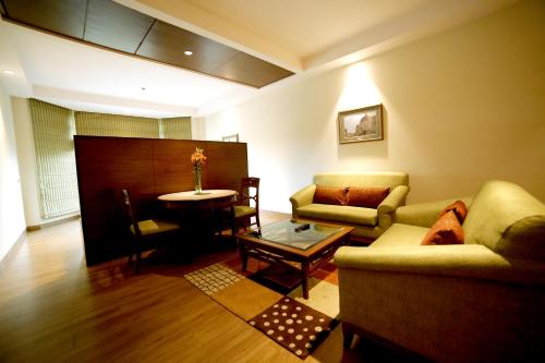 a living room with a couch and a table at The Lalit Traveller- Airport hotel in Jaipur