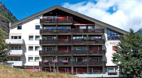 a large building with balconies on top of a hill at Apartment Zayetta Nr. 16 in Zermatt