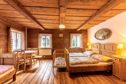 a bedroom with two beds and a table and chairs at Penzion Na Bělidle in Krásná Lípa