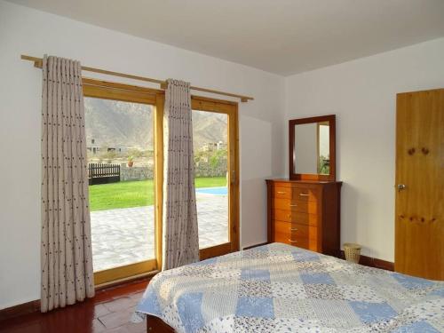 ein Schlafzimmer mit einem Bett und einem großen Fenster in der Unterkunft Casa de Campo La Luna - Cieneguilla in Cieneguilla