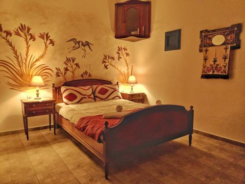 a bedroom with a bed and two night tables with lamps at Nikolakis traditional house in the village. in Kamari