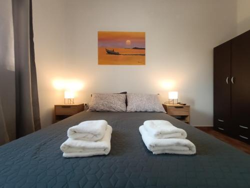 a bedroom with a bed with white towels on it at Ostria 2 Bedroom apartment near Falasarna + Balos in Plátanos